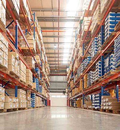 Rows of shelves with goods boxes in huge distribution 
warehouse at industrial storage factory.